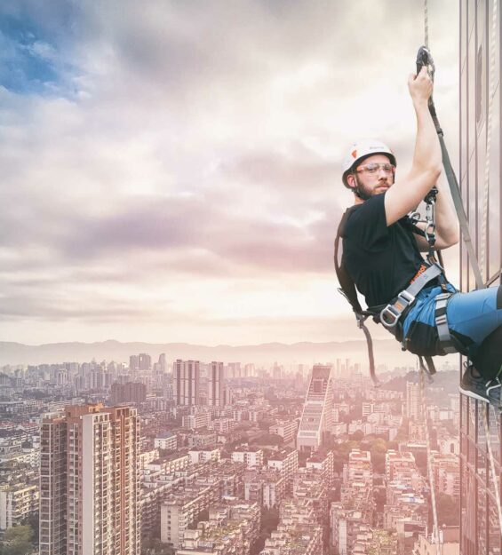 Un uomo è appeso sul lato di un edificio.