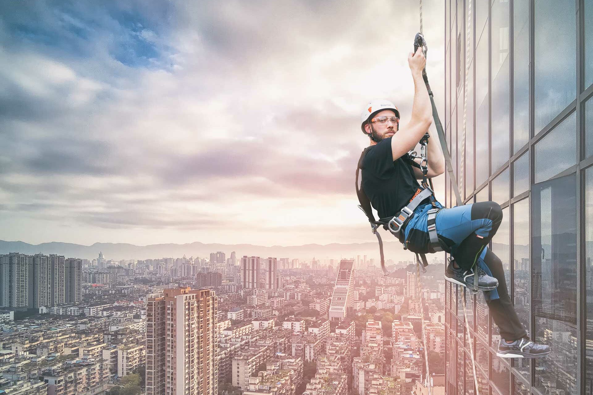 Un uomo è appeso sul lato di un edificio.